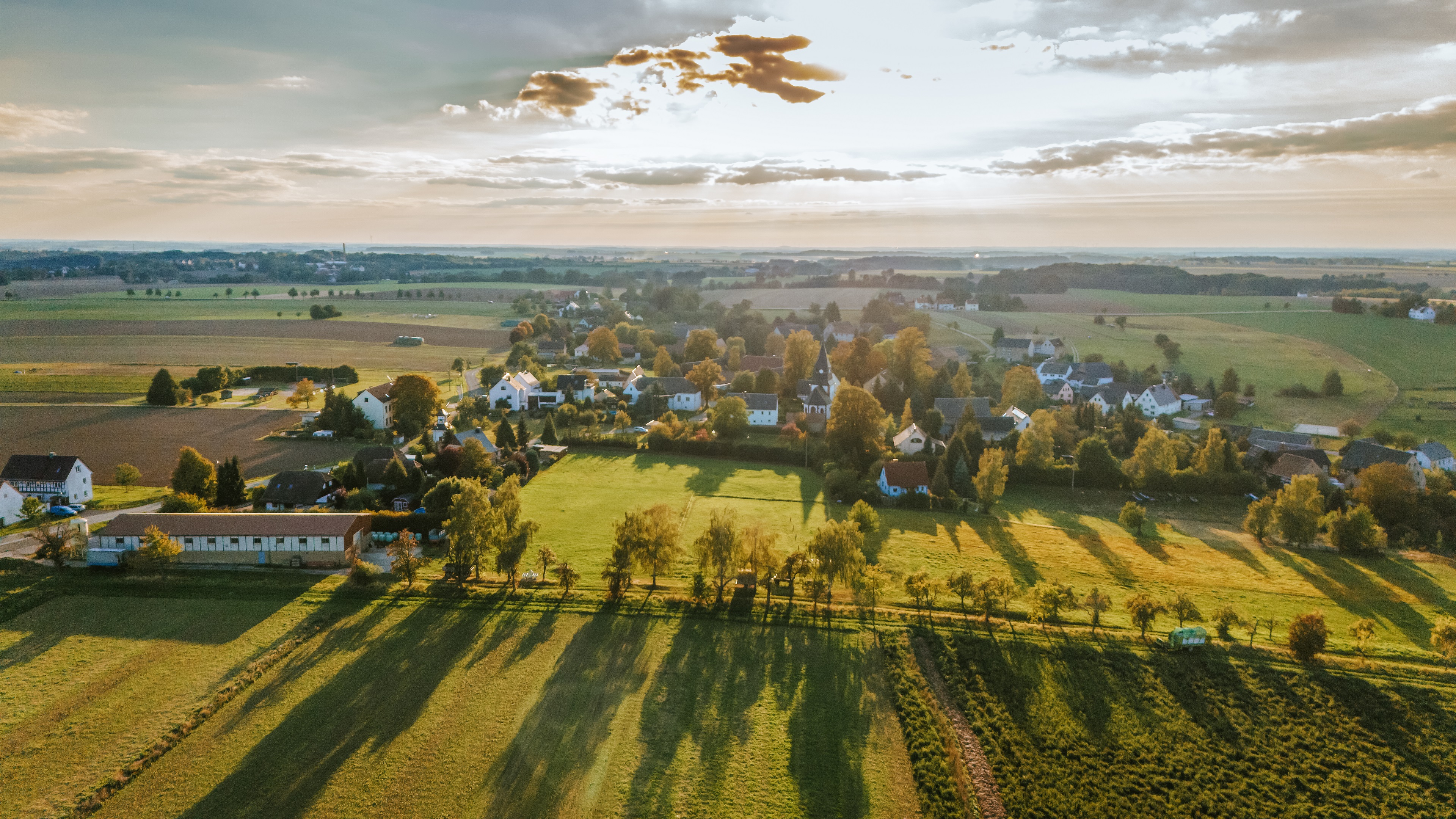 Luftaufnahme des Ortsteils Breitenborn mit locker bebautem Dorfkern, umgeben von Feldern, Wiesen und Baumreihen. Wohnhäuser mit Gärten liegen eingebettet in eine weitläufige, ländlich geprägte Landschaft.